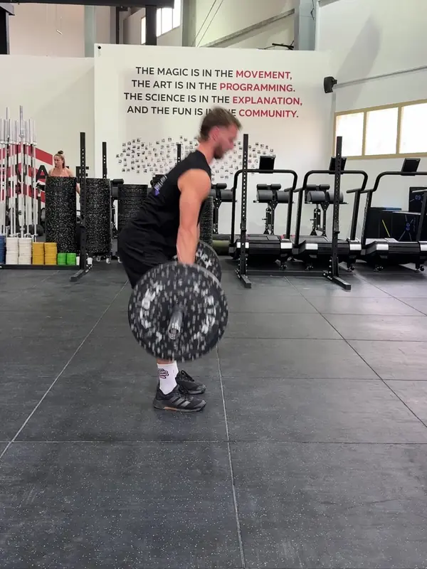 Tom with the bar just past his knees, driving his hips forward