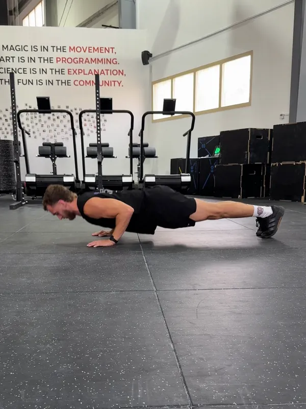 Coach Tom at the bottom of a push-up, chest just above the floor