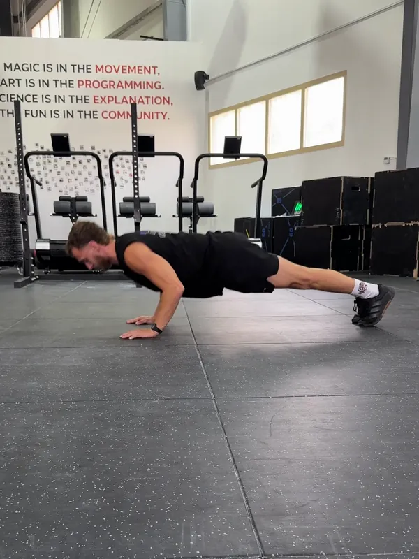 Coach Tom lowering into a push-up with his body straight and elbows bending