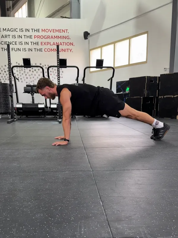 Coach Tom in the push-up start position, arms straight and body in a straight line