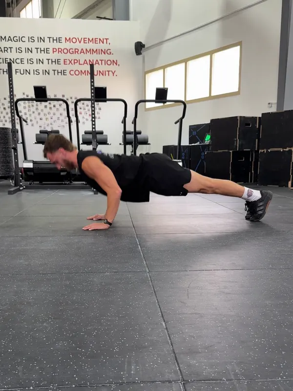 Coach Tom pressing up out of the bottom of a push-up with his body straight